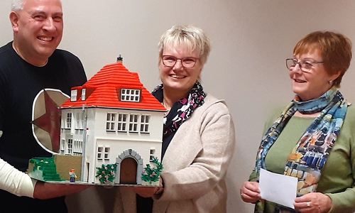 Beate Röver (Mitte), Koordinatorin im Hospizverein, freut sich über die Spende von Elke Wenzel. An dem Modell des Gutshauses, das Andreas Alischer aus Lego-Bauteilen in vielen Stunden erbaut hat, entdeckt sie immer wieder neue Details.