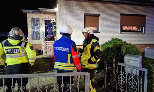 Einsatzleiter Marcel Tremer, Freiwillige Feuerwehr Abbesbüttel im Austausch mit dem Rettungsdienst; im Hintergrund wird das Gebäude von der Feuerwehr belüftet.