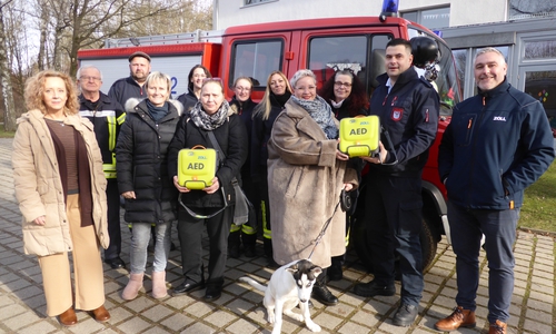 Mitarbeiterin Nicole Sengpiel, Feuerwehrmitglieder Günther Wagner und Matthias Schum, Mitarbeiterin Andrea Autschbach, Feuerwehrfrau Kim Dudenbostel, Mitarbeiterin Xenia Singethan, Feuerwehrfrauen Lena Marie Kraus und Michelle Grimm, die neue Pflegedienstleitung der Seniorenbetreuung Laura-Sophie Schäfer mit Hund Rocket, Feuerwehrfrau Christine Ahrig, Ortsbrandmeister Alexander Otte und Mitarbeiter der AED-Fa. Zoll Enrico Wolf mit dem Feuerwehrfahrzeug vor dem Gartenhaus von Schloß Schliestedt (v. li.).