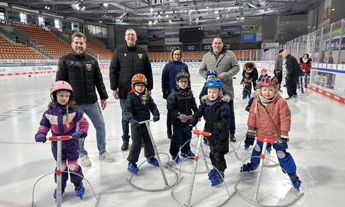 Hinten, v. li.: Simon Drühmel (Grizzlys Wolfsburg), Frank Müller (1. Vorsitzender Young Grizzlys Wolfsburg), Janine Ahrends (Fachbereich Gesundheit, LK Gifhorn) und Landrat Tobias Heilmann. In der vorderen Reihe einige Kinder der Ev. Kita Bleiche mit Hilfsmitteln für sicheren Stand auf dem Eis.