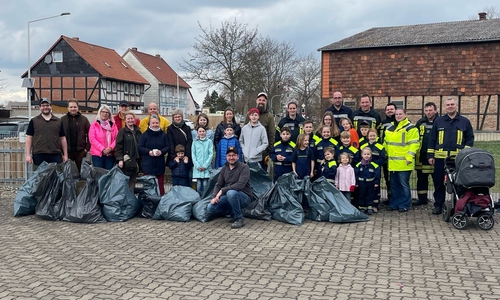 Ortsbürgermeister Michael Hofmann (vorne in der Mitte) mit den fleißigen Helfern bestehend aus den Jagdpächtern, Ortsratsmitgliedern, Familie Hennecke, Kinder- und Jugendfeuerwehr um Kinderfeuerwehrwartin Svenja Schulze und den aktiven Feuerwehrkameraden um Ortsbrandmeister André Schulze (beide rechts außen im Bild) mit den gefüllten Müllsäcken.