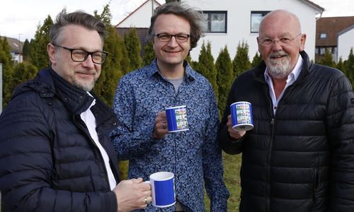 Mit dem neuen Wendessen-Kaffeebecher: (v.l.n.r.) Wolfenbüttels Bürgermeister Lukanic, Cartoonist Tobias Wagner und Ortsbürgermeister Andreas Rink.