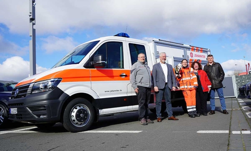 Henning Tauscher, Bereichsleiter Einsatzdienste im Johanniter-Ortsverband Braunschweig, Marco Heise von Volkswagen Nutzfahrzeuge, Hündin Amarula, Rettungshundestaffelleiterin Tamara Heise, Melanie Gue vom Johanniter-Fuhrparkmanagement des Landesverbandes und Christian Roth vom Autohaus Wolfsburg (v.l.n.r.) bei der Fahrzeugübergabe im Autohaus Wolfsburg.