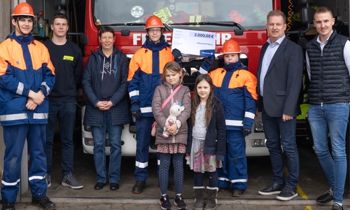 Über den Gewinn der Spende für den Kulturverein Frelle freuen sich (von links): Maximilian Henninger (Jugendfeuerwehr), Hans-Georg Ebers (Feuerwehrmann), Kathrin Ebers (1. Vorsitzende des Vereins), Heinrich Ebers (Jugendfeuerwehr), Helene Henninger, Lois Tettschlag und Henning Ebers (Jugendfeuerwehr) – Bernd Jähne (2. von rechts), Leiter der Geschäftsstelle der Öffentlichen in Königslutter, und sein Kollege Jonathan Strusch (ganz rechts) haben den Scheck persönlich übergeben.
