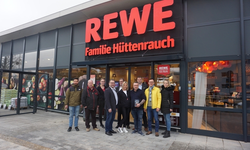 Rewe-Familie Hüttenrauch feiert Wiedereröffnung, hintere Reihe v.l.: Kamil Boltuc, Dirk Ueckermann, Belinda Starke, Ralf Keffel und Matthias Keil (alle REWE Group), vordere Reihe v.l.: Ortsbürgermeister Sabah Enversen, Sabine und Mike Hüttenrauch, Thomas Werner (WMG-Wirtschaftsförderung) und Kerstin Grimminger (WMG-Wirtschaftsförderung).