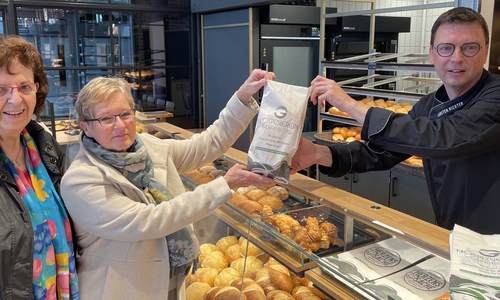 Carsten Richter stellt seine neuen Brötchentüten vor. Darauf wirbt er um Spenden für das im Bau befindliche HospizZentrum. Die Hospizdamen Ulrike Jürgens (links) und Heidemarie Wypich bedanken sich für diese originelle Unterstützung.