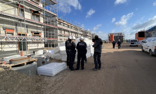 Zöllnerinnen und Zöllner in einem Neubaugebiet.