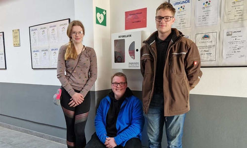 Adina Buchholz, Mattis Buchheister, Maximillian Battermann – ausgebildete „Juniortrainer-Herzensretter“ neben dem Defibrillator der OBS Sickte.