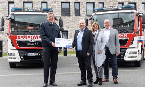 Thomas Seil, Claudia Müller und Jens-Folker Huismann vom Team der Öffentlichen Versicherung Braunschweig (rechts) übergeben den Scheck für die Anschaffung der neuen Löschfahrzeuge an Torge Malchau (links), Fachbereichsleiter der Feuerwehr Braunschweig.
