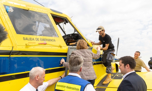 Ministerin Behrens erklimmt das Löschflugzeug.