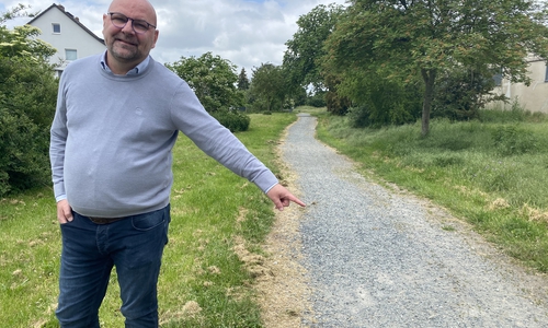 Ortsbürgermeister Marc Angerstein zeigt auf den zu sanierenden Verbindungsweg im Wolfenbütteler Ortsteil Fümmelse. Im Herbst rollen die Bagger an. 