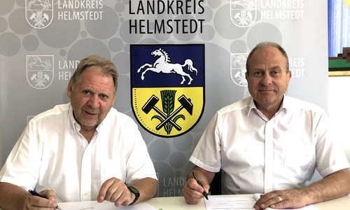 (v.l.): Wito Johann (KWG) und Landrat Gerhard Radeck unterzeichnen die Betreuungsvereinbarung.