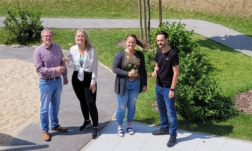 Der Abteilungsleiter für Kindertagesstätten, Andreas Binner (l.) und der KiTa Leiter Marco Waldt, übergeben ein kleines Dankeschön an Teammitglieder der KiTa Entdeckerhafen. 
