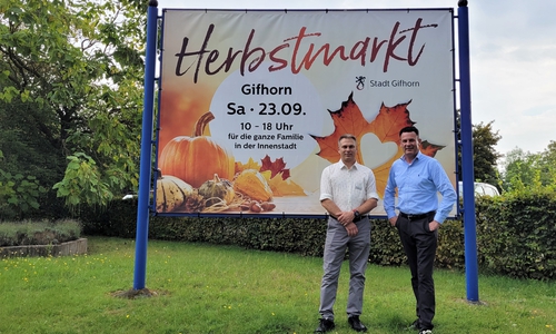 Thomas Meinecke (Fachbereich Kultur/Soziales) und Bürgermeister Matthias Nerlich vor dem Veranstaltungsplakat.