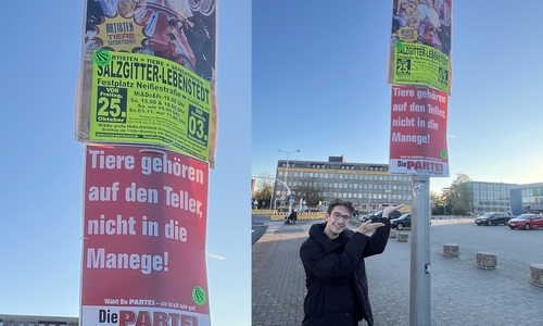 Canjoel Kaya vor dem Plakat vor dem Rathaus. 