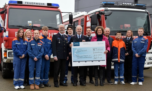 Nina Krumme, Volkswagen AG, übergibt den Spendenscheck in Anwesenheit von Mitgliedern der Jugendfeuerwehren Stöckheim, Watenbüttel, Völkenrode und Lamme an Harald Herr vom Förderverein Feuerwehr und Jugendfeuerwehr Braunschweig.