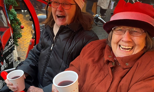 Mit leckerem Glühwein in der Hand freuen sich diese beiden Damen über den spaßigen Ausflug auf den Weihnachtsmarkt.