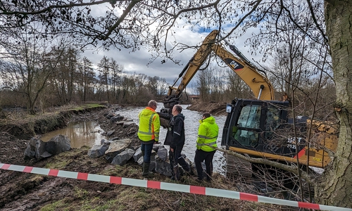 Mit schwerem Geschütz gegen den Durchbruch der Oker in Vienenburg: Der Fachdienstleiter Umwelt und Gewässerschutz der Stadt Goslar, Dirk Sielaff (li.), macht sich mit seinem Kollegen Maximilian Delius (re.) vor Ort ein Bild von den Arbeiten.