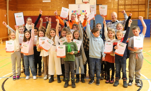 Die Kinder freuen sich über ihre Siegerurkunden, 250 Euro Preisgeld für die Klassenkasse und den Pokal.