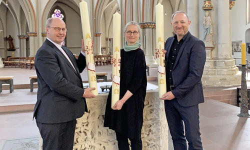 Propst Martin Tenge (links) hat die Osterkerzen am heutigen Gründonnerstag an Dompredigerin Cornelia Götz und Propst Lars Dedekind vor dem Altar in St. Aegidien übergeben. 