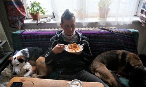  Das aktuellste Bild zeigt mutmaßlich Burkhard Garweg zwischen zwei Hunden auf dem Sofa sitzend und essend.
