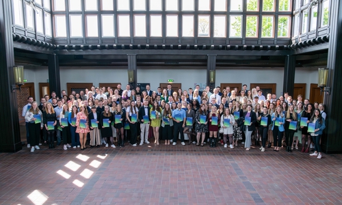 Die Absolventinnen und Absolventen mit ihren Abschlussurkunden.