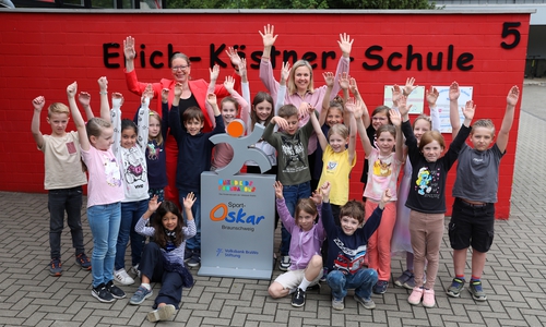 Schüler der Erich-Kästner-Schule in Weddel freuen sich über die Sport-Oskar Trophäe, die ihnen von Nicole Mölling, Botschafterin von United Kids Foundations, übergeben wurde.