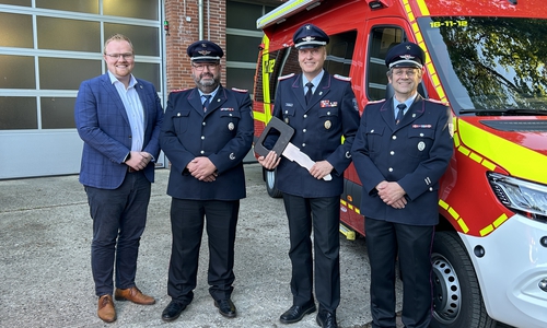 Vor dem neuen Einsatzfahrzeug: Samtgemeindebürgermeister Henning Evers (links) zusammen mit der Feuerwehr.