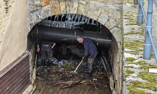 Das freiliegende Abwasserrohr unterhalb der Königsbrücke stellt eine zusätzliche Herausforderung dar: Hier können sich Treibgut und Totholz leicht verkeilen. Die Entfernung der Anschwemmungen kann aber nur per Hand und Schaufel erfolgen.