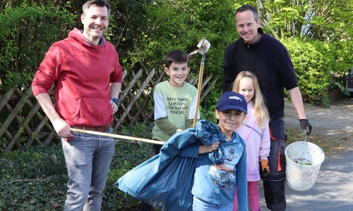 Väter sammelten mit ihren Kindern Müll im Dorf ein. 