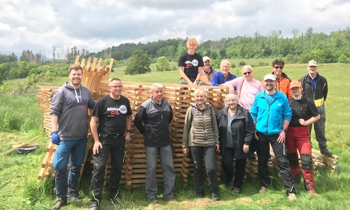 Im Einsatz zum Schutz der jungen Laubbäume im MachMit!Wald: Ehrenamtliche Helfer bauen am Steinberg einen Wildschutzzaun aus Hordengatter.