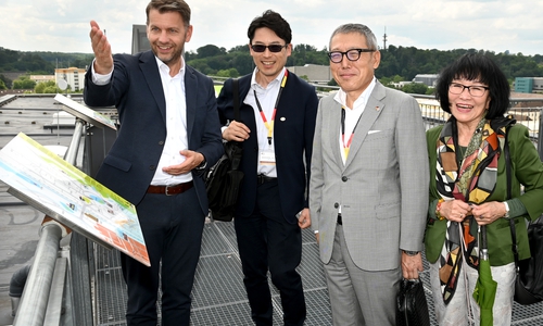 Oberbürgermeister Dennis Weilmann (links) zeigt der Delegation mit Goro Kamino (zweiter von rechts) und Teruko Balogh-Klaus (rechts) die Stadt von oben.