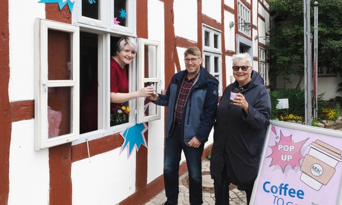 Freuen sich über heißen Kaffee: Andreas Meyer (Mitte) und Monika Kiekenap-Wilhelm (rechts) bekommen von einer Museumsmitarbeiterin ihren Coffee to go ausgehändigt.