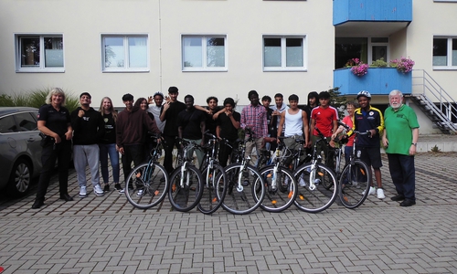 Gruppenfoto mit den Jugendlichen nach dem Fahrradparcours und am Reaktionstest-Fahrsimulator.