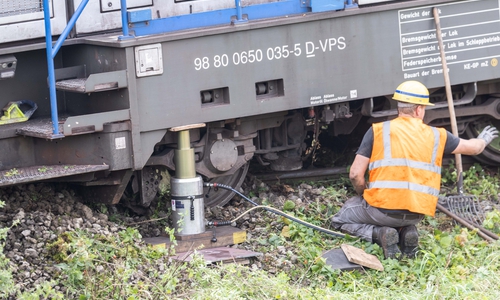 Mit Hydraulikhebern wird versucht, die Lok wieder in die Spur zu bringen.