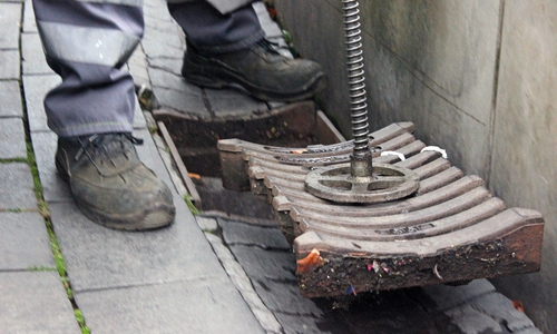 Gully-Pflege: Mit einem speziellen Hebegerät wird das Gitter über dem Sinkkasten abgehoben.