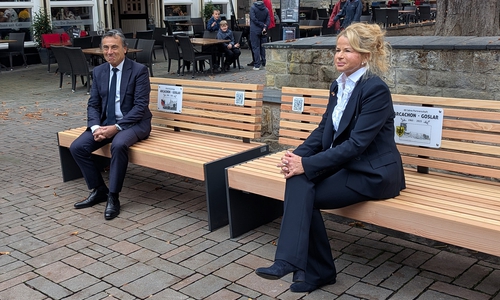 Sie bieten künftig nicht nur Platz für einen regen Austausch: Die zwei Partnerschaftsbänke am Rathaus laden auch dazu ein, die Grußworte von Oberbürgermeisterin Urte Schwerdtner (re.) und Arcachons Bürgermeister Yves Foulon (li.) per QR-Code zu hören und zu sehen.