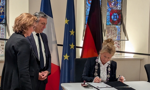 Oberbürgermeisterin Urte Schwerdtner (re.) unterzeichnet vor Arcachons Bürgermeister Yves Foulon (Mitte) die neue Partnerschaftsurkunde. Dagmar Mönnecke-Koroma (li.), Stadt Goslar, übersetzte während der gesamten Veranstaltung.