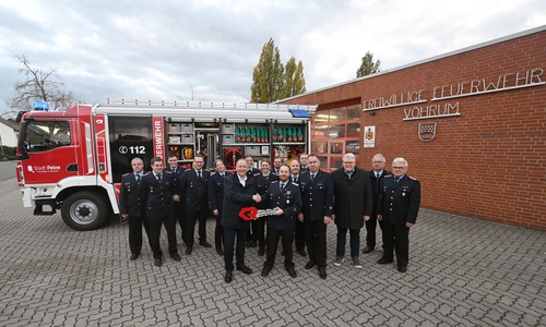 Bürgermeister Klaus Saemann übergibt einen symbolischen Fahrzeugschlüssel an Ortsbrandmeister Sebastian Goldmann.  