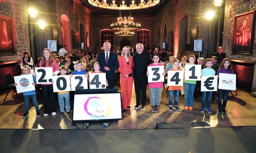 Kinder mit der Spendensumme, in der Mitte von links nach rechts: Jürgen Brinkmann, Jenny Richter (Moderatorin RTL Nord), Robert Lübenoff.