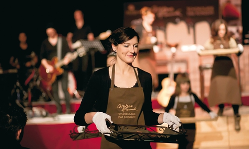 Die Schokoladen-Botschafter servieren während des Konzerts die live auf der Bühne zubereiteten Schokoladen-Pralinen. 