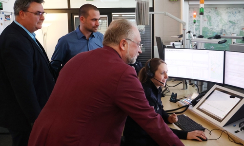 Lars Oehmke (Geschäftsführer Rettungsdienst Cuxland gGmbH), Dr. Benjamin Junge (Ärztlicher Leiter des Rettungsdienstes im Landkreis Cuxhaven) und Ulrich Bruns (Fachdienstleiter Rettungswesen beim Landkreis Goslar) blicken in der Goslarer Leitstelle Laura Jodat über die Schulter.