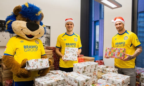 Leo, Louis Breunig und Sebastian Polter (v. l.) von Eintracht Braunschweig helfen tatkräftig beim Geschenke verpacken.