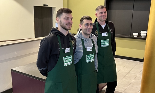 Geschäftsführer Nils Mittmann, Head Coach Costas Papazoglou und Spieler Ferdinand Zylka von den Basketball Löwen tauschten kurzfristig die Trikots gegen Schürzen.