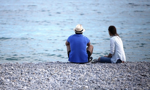Mann und Frau sitzen am Strand