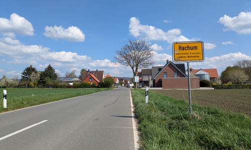 Die Kreisstraße 7 mit Blick auf den westlichen Ortseingang von Hachum. Hinter dem Ortseingangsschild weist bereits ein Schild des Landkreises Anrainer und Verkehrsteilnehmer auf die kommende Baumaßnahme hin.