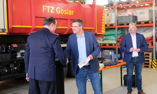 Dr. Alexander Saipa überreicht den Geehrten, wie hier dem Langelsheimer Bürgermeister Ingo Henze (links), die Urkunde. Erster Kreisrat Frank Dreßler (rechts) übernimmt das Anstecken der dazugehörigen Bandschnalle.