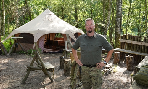 Stefan Winkler vor dem Gruppenzelt in seinem Survivalcamp.