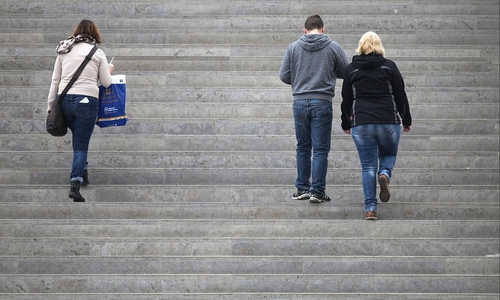 Drei Personen gehen eine Treppe hinauf (Archiv)