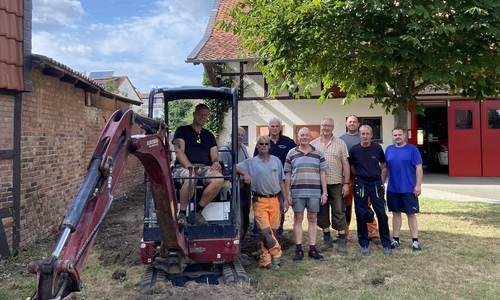 Erster Spatenstich für das Kleine Spritzenhaus: Im Bagger Ortsbrandmeister Matthias Hartlich, dann weiter von links Jens und Christian Behrens, Henning Plumeyer, Helge Michler, Frank Oesterhelweg, Simon Gloger, Bernd Isaak und Tim Helbig.